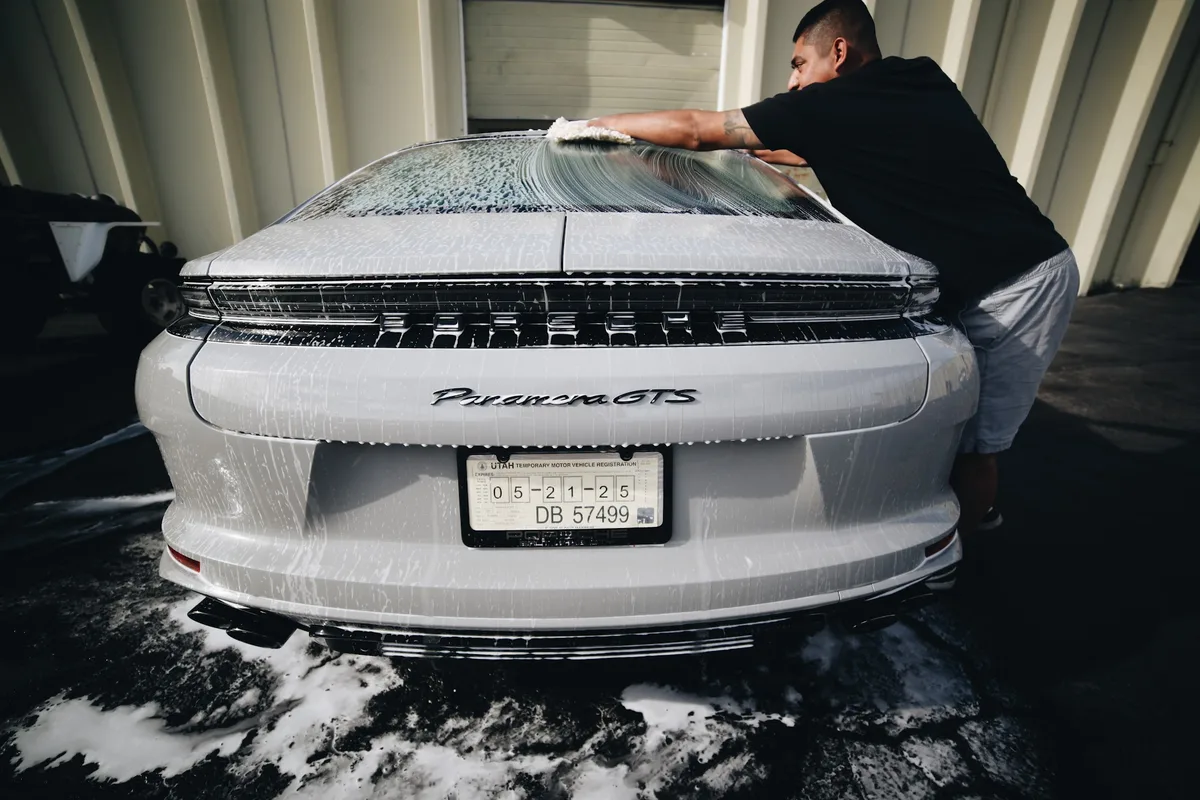FRQNCY technician hand-prepping a Porsche Panamera GTS for paint correction